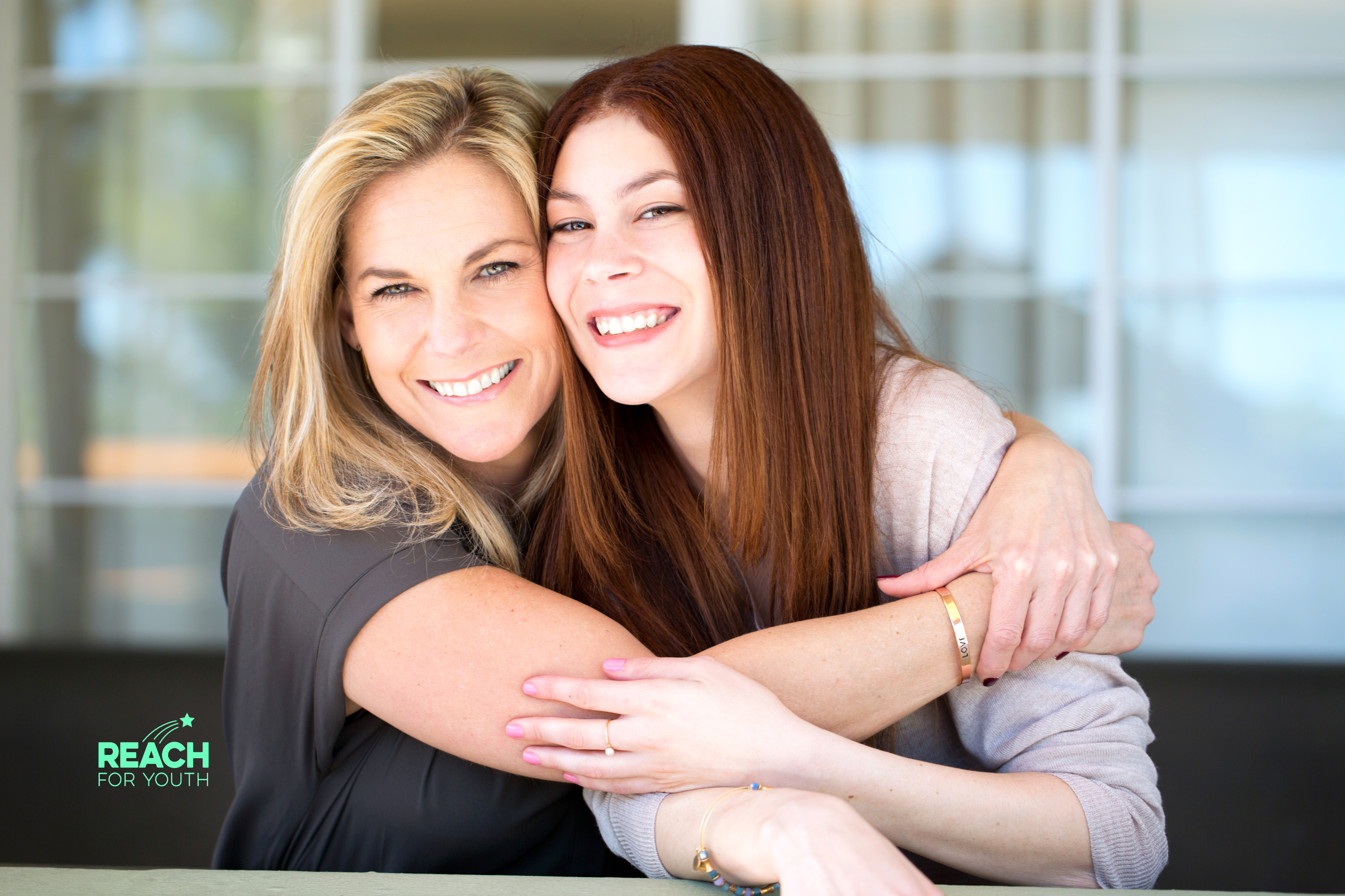A parent and teenager embracing in a hug